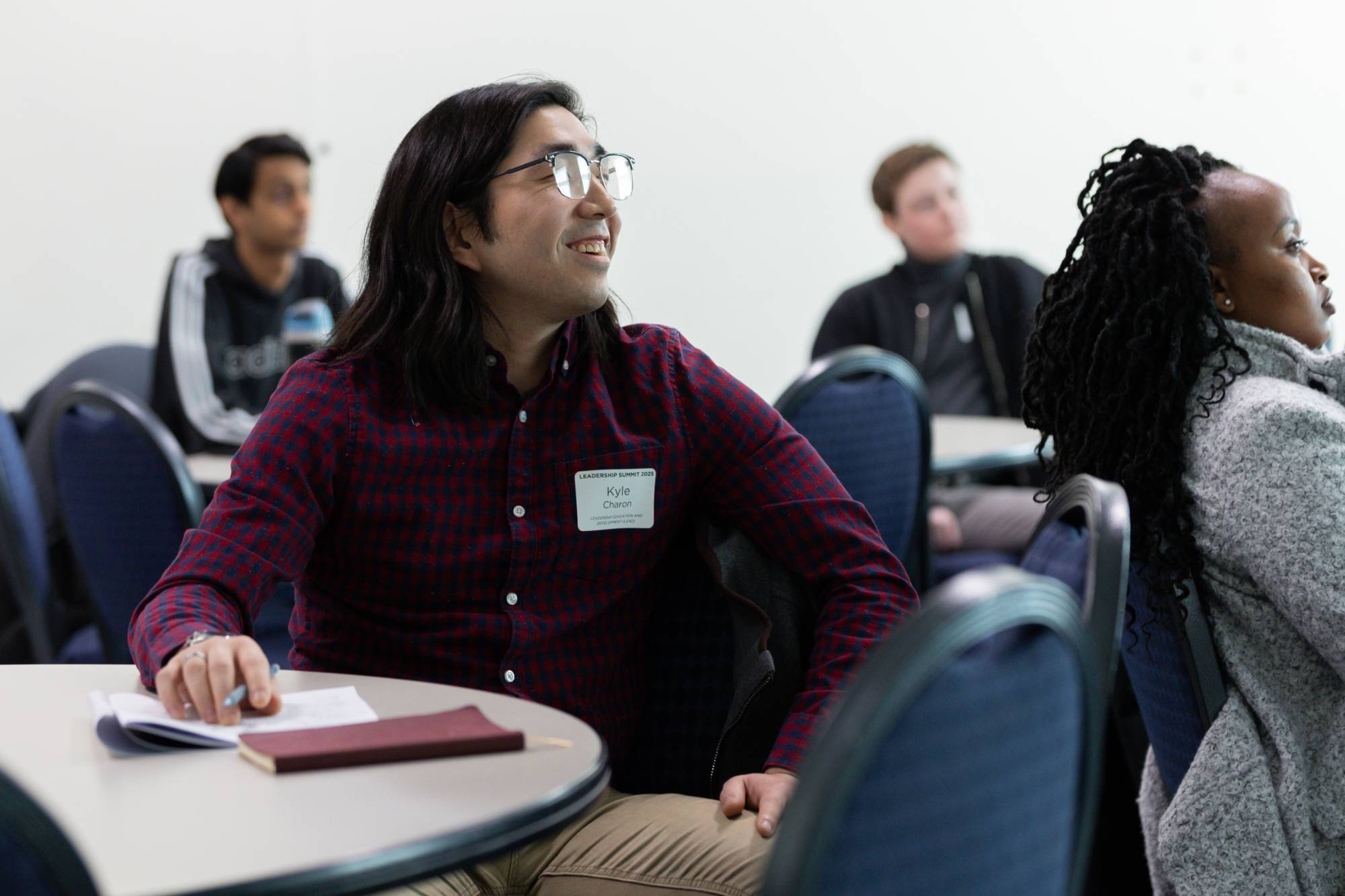student smiling while listening to a presentation